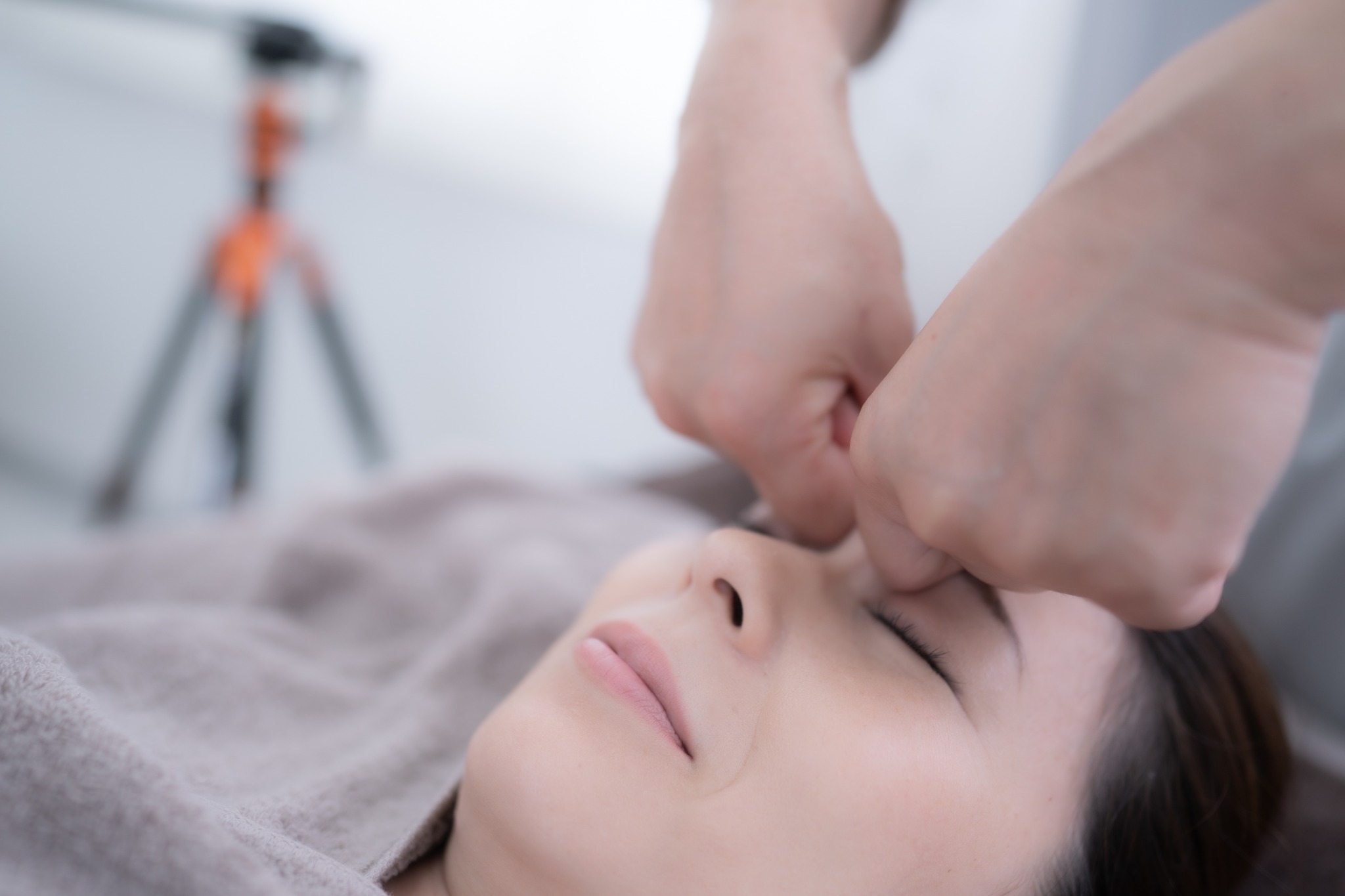 顔まわりを手で丁寧にケアするフェイシャルの施術シーン